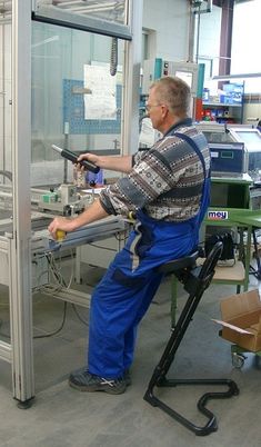 a man in overalls working on an assembly line