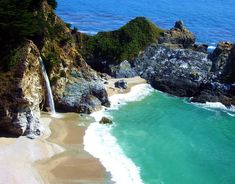 an aerial view of the beach and waterfall