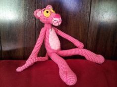 a pink stuffed animal sitting on top of a bed