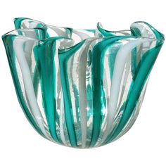 a green and white glass vase sitting on top of a table