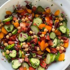 a white bowl filled with assorted vegetables on top of a table