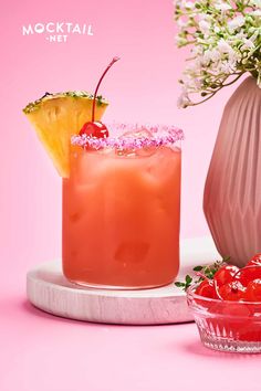 two cocktails with pineapple and cherry garnish sit next to each other