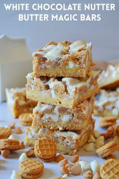 white chocolate nutter butter magic bars stacked on top of each other with nuts scattered around them