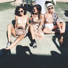 three young women sitting on the ground in bathing suits