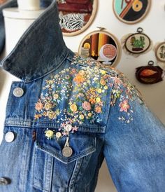 a denim jacket with embroidered flowers on it