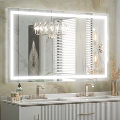 a bathroom vanity with two sinks and a large lighted mirror over the sink in front of it