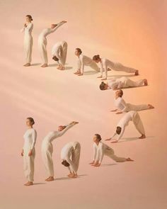 a group of people in white doing yoga poses