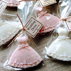 small pink and white wedding cakes in plastic bags with tags on the top, tied to twine strings