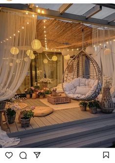 a porch with a swing chair and lights hanging from it's ceiling over the deck