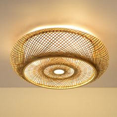 a round light fixture hanging from the ceiling in a room with gold walls and flooring