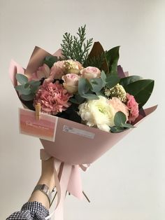 a person holding a bouquet of flowers in their hand with the tag attached to it