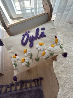 a pillow with the word okla written on it sitting on a chair in front of a window