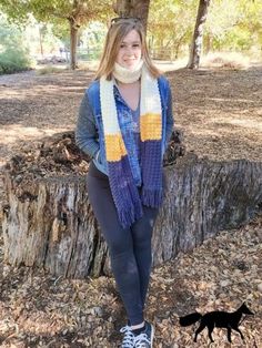 a woman standing in front of a tree stump wearing a scarf and converses sneakers