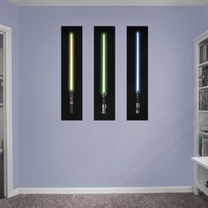 two lightsabes are hanging on the wall next to a bookshelf in a room