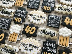 decorated cookies with happy birthday and cheers written in black, yellow and white frosting