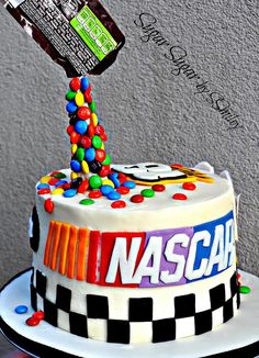 a birthday cake decorated with candy, candies and the name nascar on it is being tossed by someone