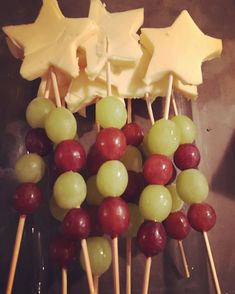 grapes and cheese are arranged on skewers to look like stars