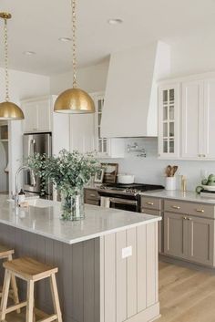 a kitchen with two stools and an island in the middle, surrounded by white cabinets