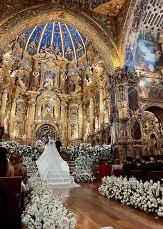 the bride is walking down the aisle in her wedding dress and bouquets on the floor