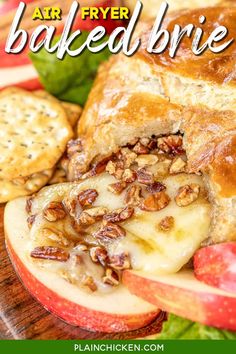 baked brie with apples and walnuts on a cutting board next to crackers