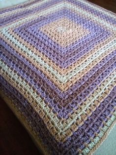 a crocheted blanket sitting on top of a bed