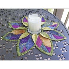 a candle is sitting on top of a table with a flower design in the center