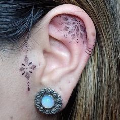 a woman's ear has a tattoo on it