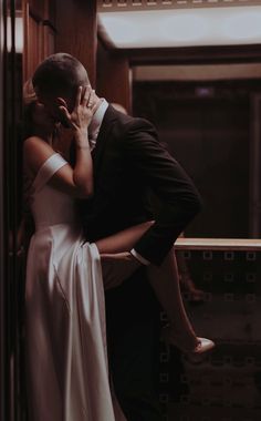 a bride and groom kissing in an elevator