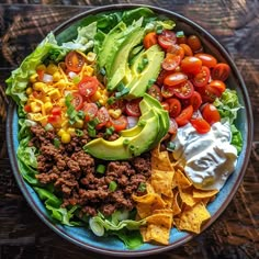 a salad with lettuce, tomatoes, corn, avocado and other toppings