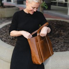 Finally - a show-stopping leather tote that can accommodate your needs (and your hats!) The Natalie's diverse functions keep your hat, blanket, or travel pillow secure and accessible! A large exterior pocket is perfect for your phone or reading material, while the raw leather interior is spacious enough for your weekend getaway supplies or everyday essentials. The bottom two snaps on the leather straps allow for wider-brimmed hats (image shown with 13.5" hat) and the detachable crossbody strap g Paper Grocery Bags, Raw Leather, Reading Material, Wide Brimmed Hats, Leather Interior, Very Well, Grocery Bag, Travel Pillow, Leather Tote