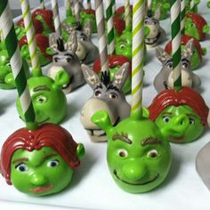 there are many green and red cake pops with faces on them