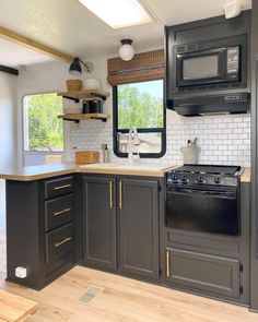 a kitchen with gray cabinets and black appliances