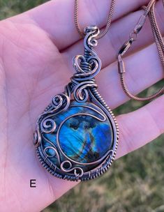 a person is holding a blue pendant in their hand