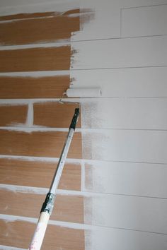 a paint roller is being used to paint a brick wall with white paint on it