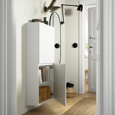 an open door leading into a white room with bookshelves and shelves on the wall