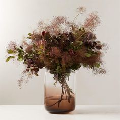 a vase filled with lots of flowers on top of a table