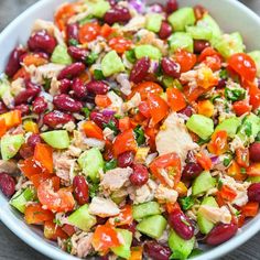 a white bowl filled with lots of different types of food on top of a wooden table