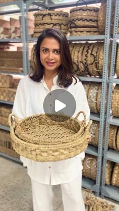 a woman holding a wicker basket in front of shelves filled with woven baskets and other items