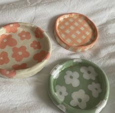 three small bowls sitting on top of a white sheet