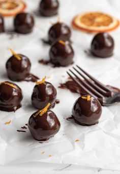 chocolate candies with orange peels on top and forks next to them, ready to be eaten