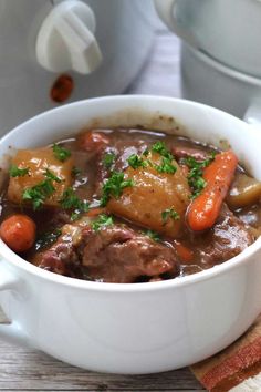 a white bowl filled with stew and carrots