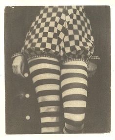 an old black and white photo of a woman in tights with checkered stockings