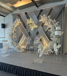 a stage set up with white flowers and chairs