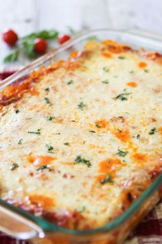 a casserole dish with cheese and vegetables in it on a checkered cloth