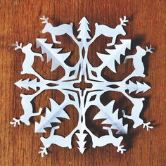 an origami snowflake on a wooden table with white paper cut out