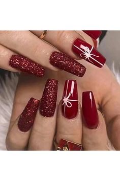 red and white nail designs with bows on the tip of their nails, in front of a woman's hand