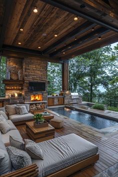 an outdoor living area with couches, tables and a fire place in the background