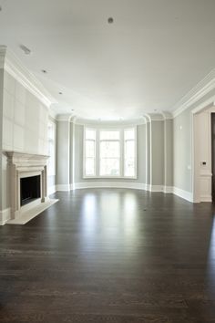 an empty living room with white walls and wood floors