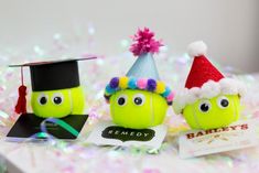 two tennis balls with funny faces and hats on them, sitting next to each other