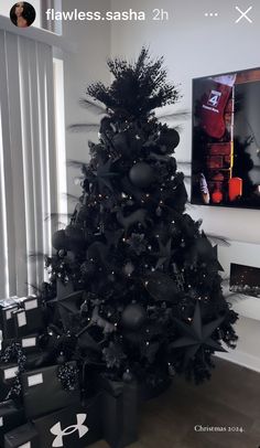 a black christmas tree with presents under it